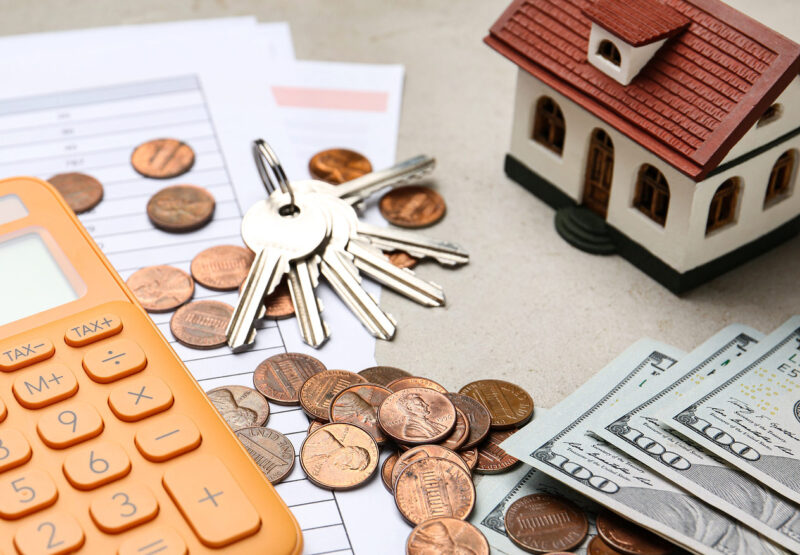 House model with calculator, documents, keys and money on table, closeup. Real estate agent service